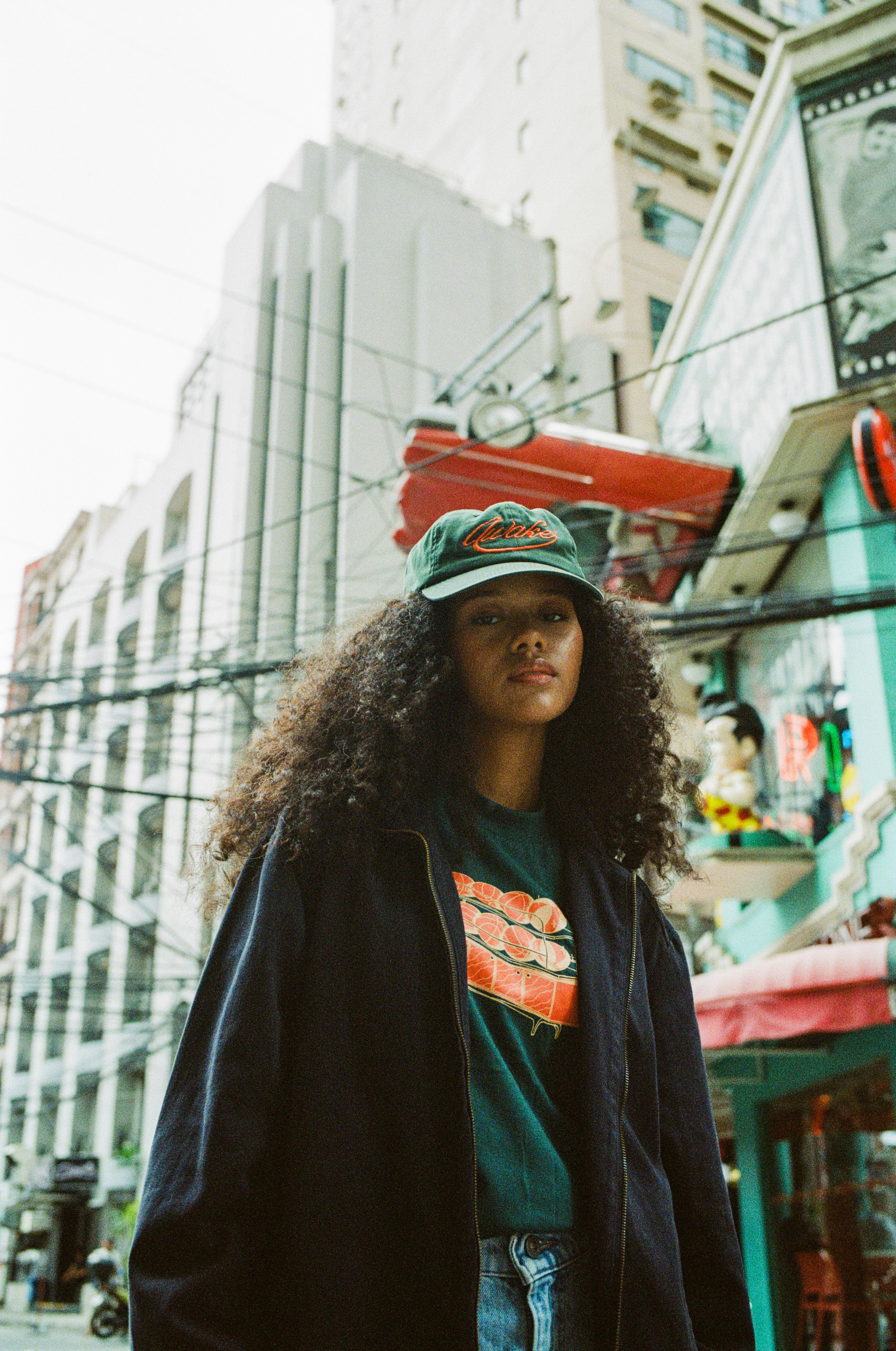 Young woman with curly hair and vintage jacket, artsy Berlin style